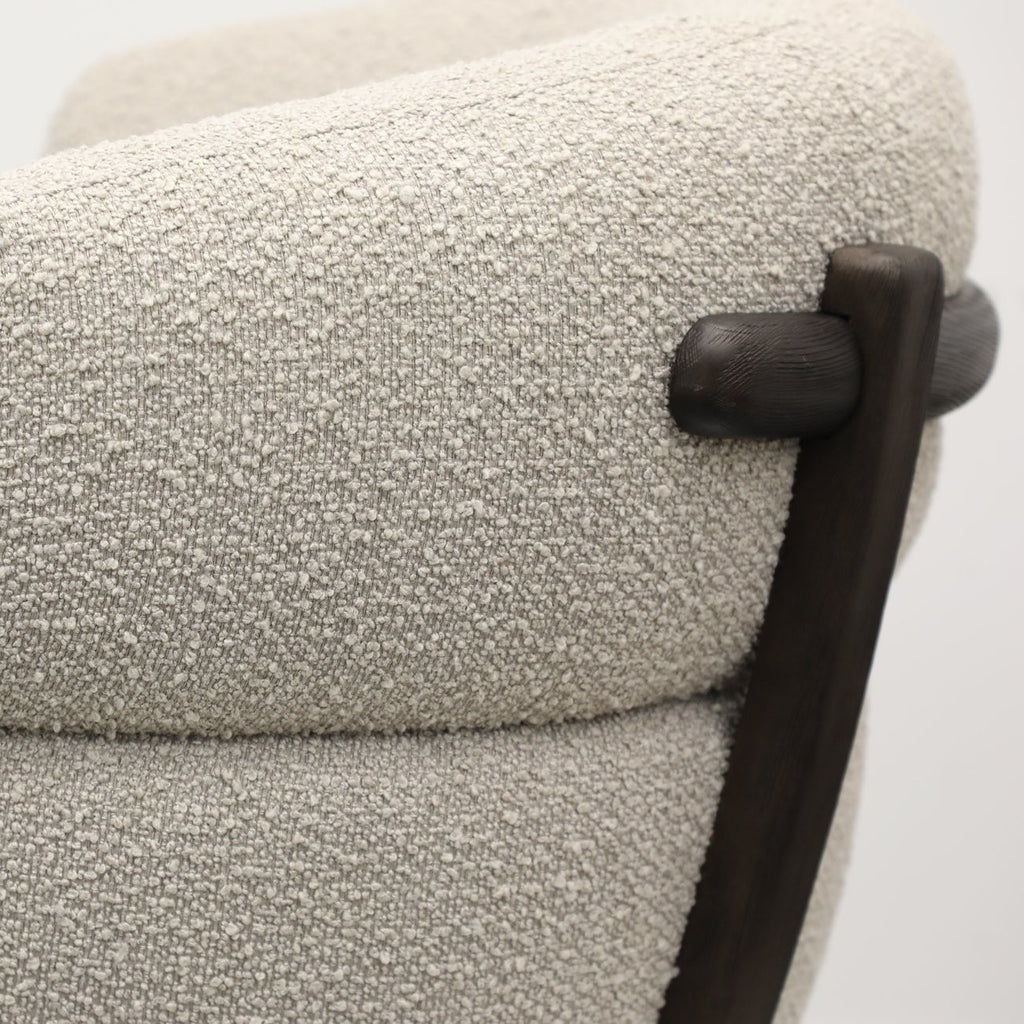 Close-up of ivory boucle fabric texture on a modern swivel chair, highlighting soft and tactile weave