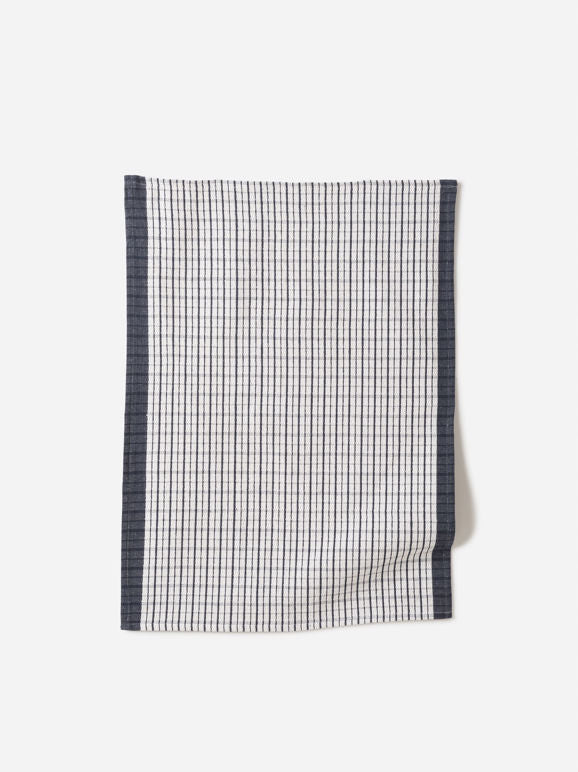 Navy and white grid-patterned linen tea towel with dark border, photographed against a light background.