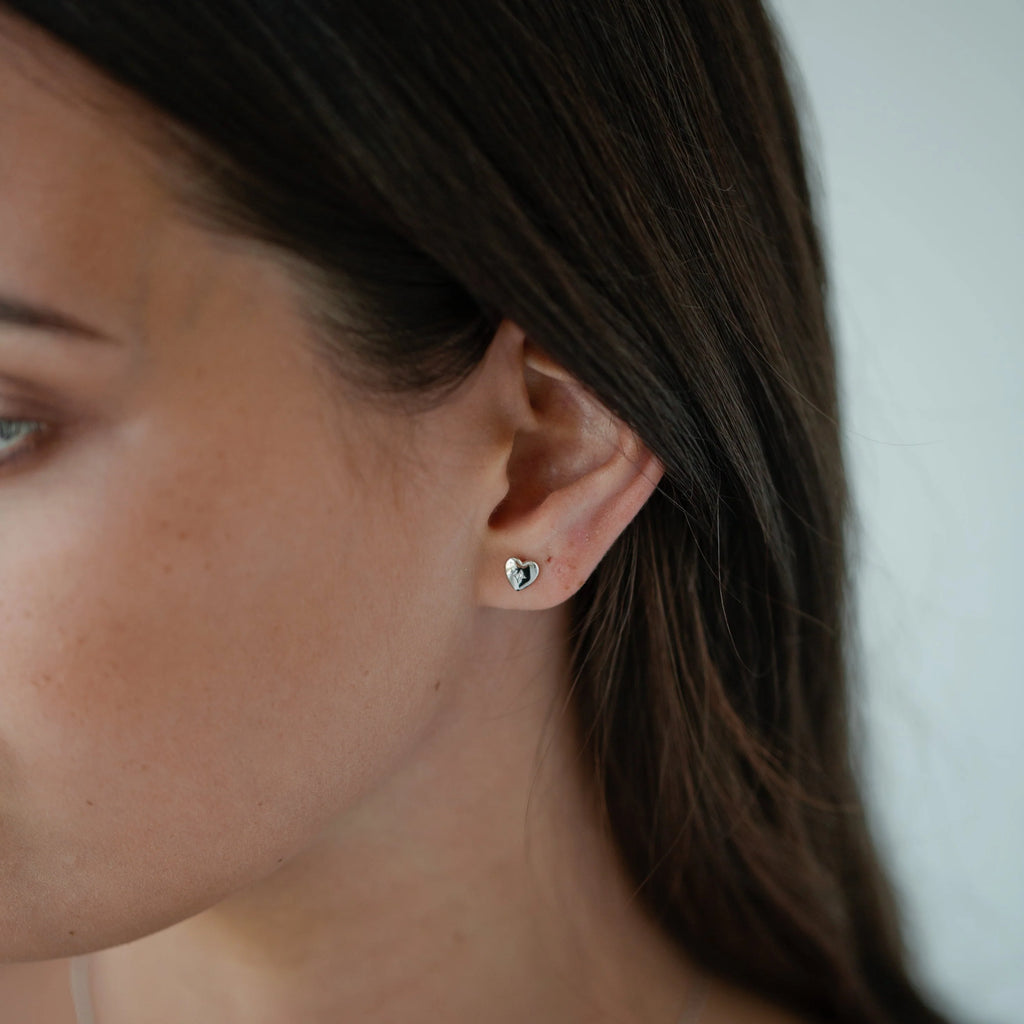 Petit heart silver stud earring with embedded stone worn by model