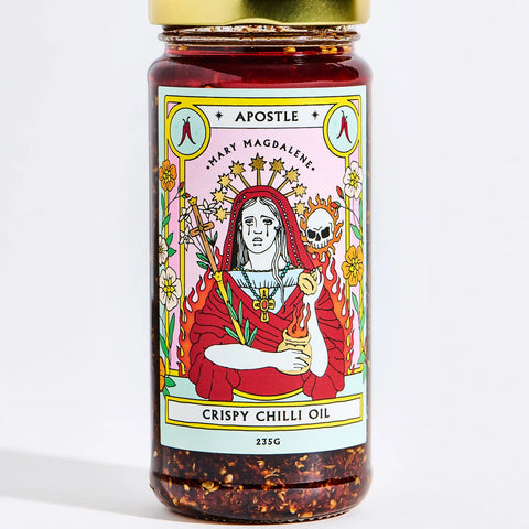 Jar of Apostle Crispy Chilli Oil, 235g, featuring a vibrant Mary Magdalene illustration on the label with a gold lid and visible chilli flakes