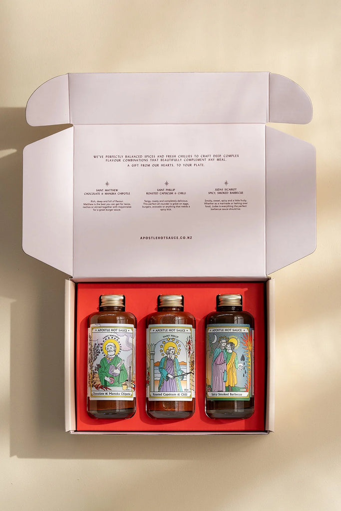 Gift box set of Apostle hot sauces featuring Chocolate & Manuka Chipotle, Roasted Capsicum & Chilli, and Spicy Smoked Barbecue in illustrated bottles.