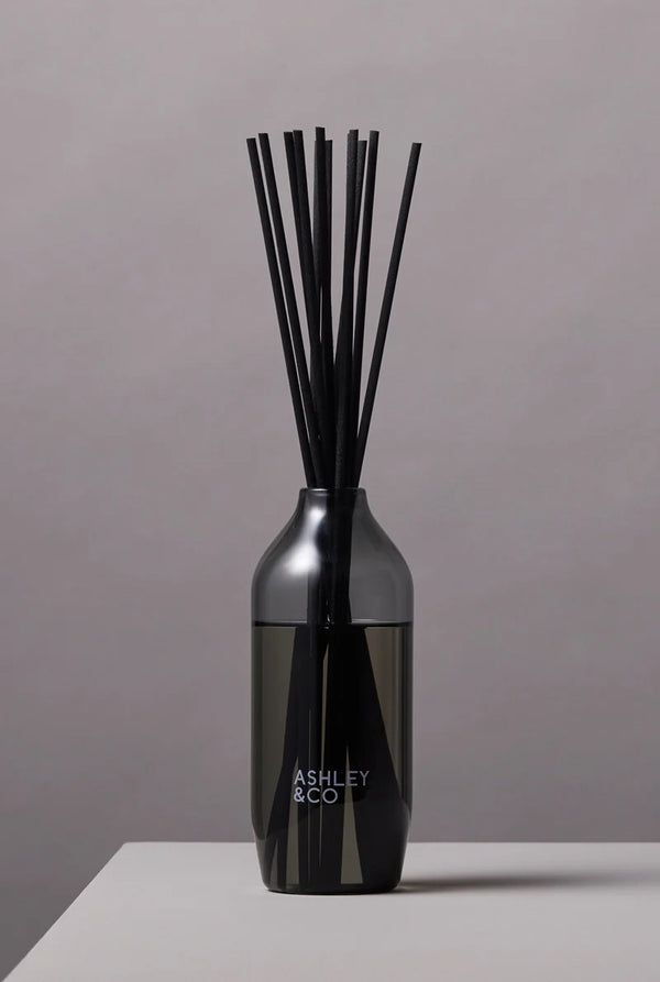 Ashley & Co black reed diffuser in a sleek tinted glass bottle, minimalist home fragrance for long-lasting scent and modern interior style.