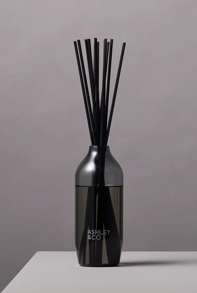 Ashley & Co black reed diffuser in a sleek tinted glass bottle, minimalist home fragrance for long-lasting scent and modern interior style.