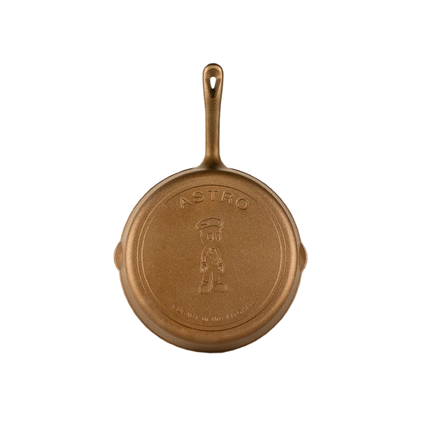 Gold cast iron skillet with 'ASTRO' branding 