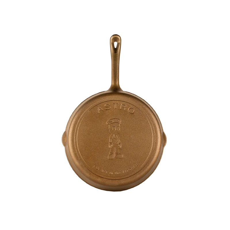 Gold cast iron skillet with 'ASTRO' branding 