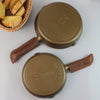 Two gold ASTRO cast iron skillets with leather handles cast iron pans