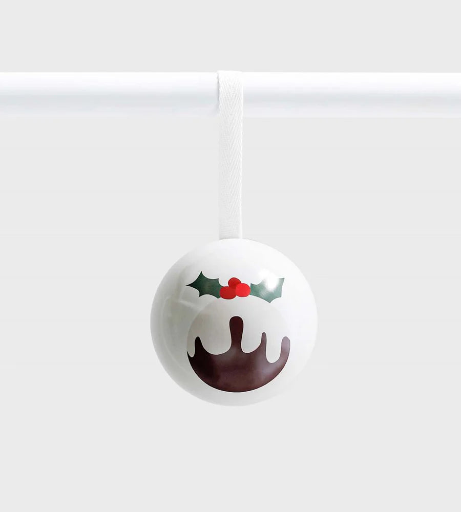 White ceramic ornament featuring a Christmas pudding design with holly and berries, hanging from a white ribbon against a light grey background
