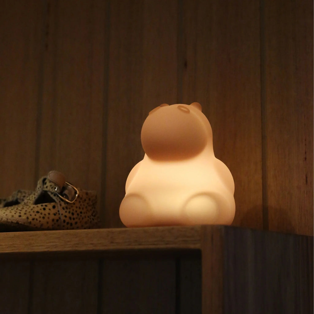 Hippo nightlight on shelf, lit up and glowing for kids that are scared of the dark. 
