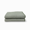 A folded cloth with a green and white checkerboard pattern, shown on a clean white background.