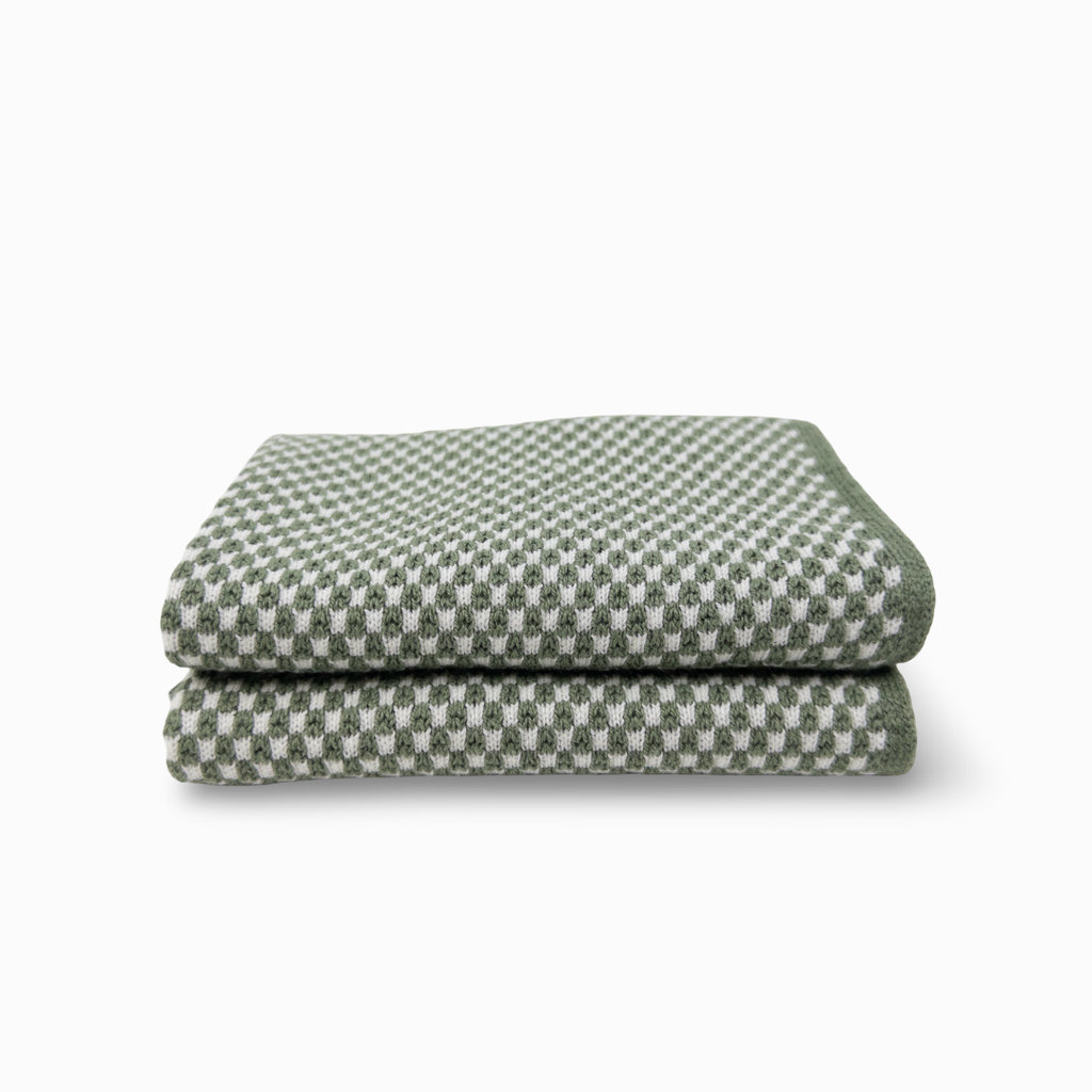 A folded cloth with a green and white checkerboard pattern, shown on a clean white background.
