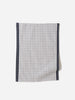 Navy and white grid-patterned linen tea towel with dark border, photographed against a light background.