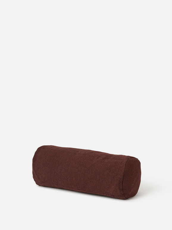 Cylindrical bolster in rich burgundy fabric, designed for restorative poses, meditation support, or home decor accent.