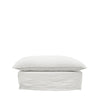 Minimalist white linen ottoman with a cushioned top and structured base, shown on a plain background.