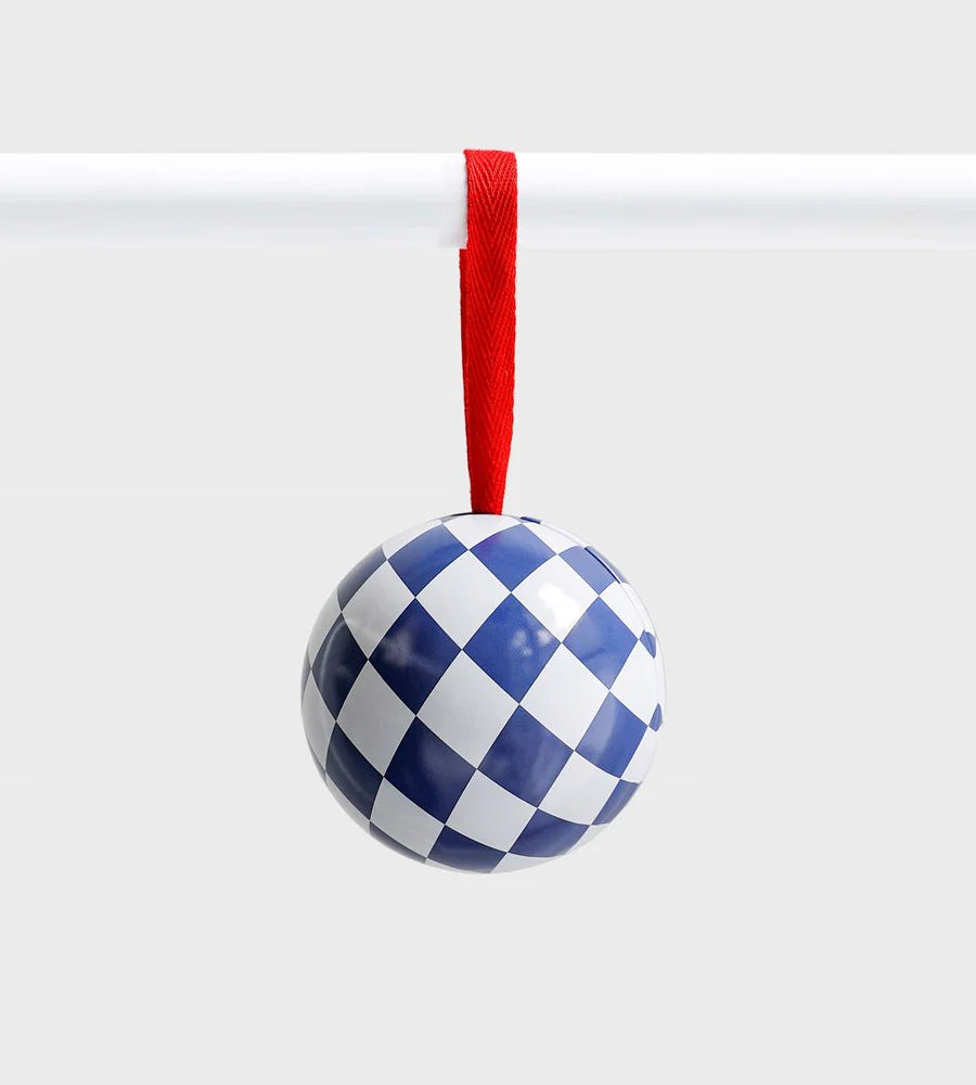 Blue and white checkered ceramic ornament with a glossy finish, suspended from a red ribbon against a light grey background