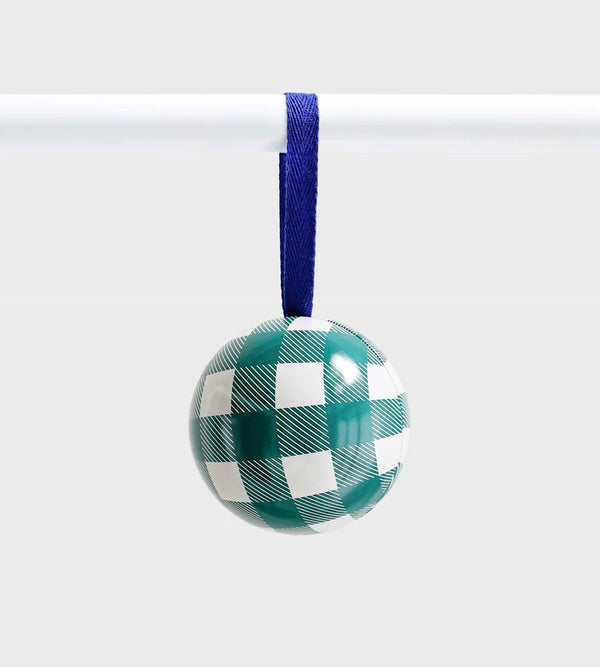 Green and white checkered ceramic ornament with fine diagonal detailing, hanging from a royal blue ribbon against a light grey background