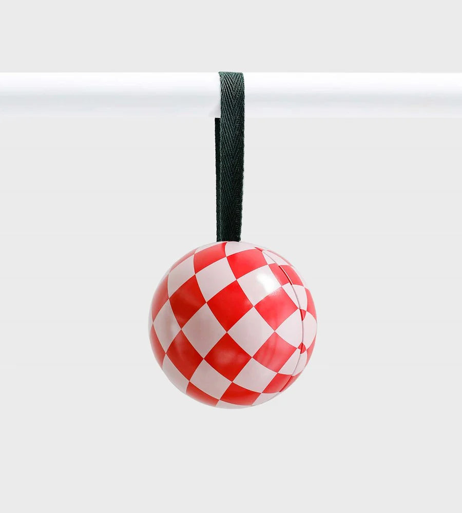 Red and white checkered ceramic ornament with a glossy finish, hanging from a dark green ribbon against a light grey background