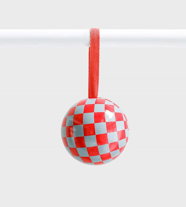 Red and pale blue checkered ceramic ornament with glossy finish, hanging from a red ribbon against a light grey background