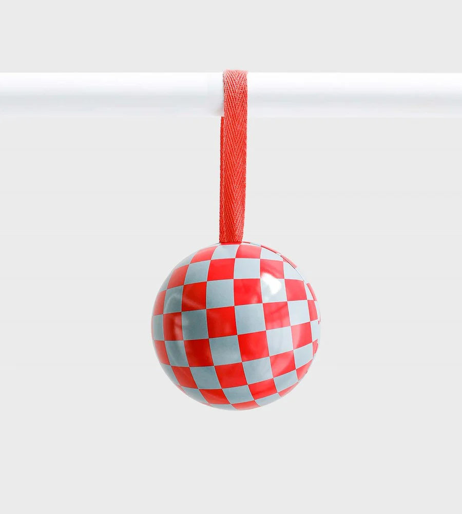Red and pale blue checkered ceramic ornament with glossy finish, hanging from a red ribbon against a light grey background