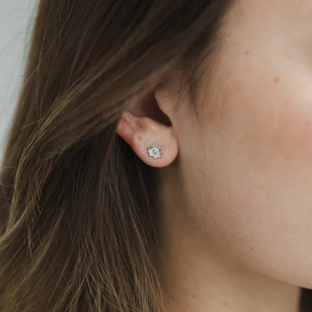 Close-up of an ear wearing a lily stud earring with pearl model wears sterling silver