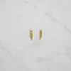 Gold crystal mesh fringe stud earrings laid flat on a white marble surface, showcasing their elegant drape and sparkle.