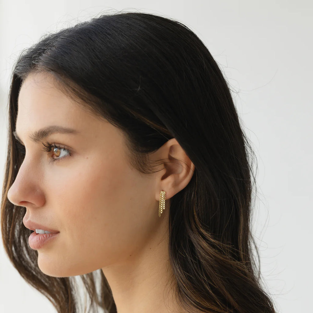 Model wearing gold crystal mesh fringe earrings, styled with loose waves and a minimalist look for an elegant, modern finish.