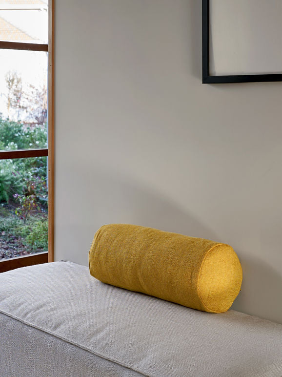 Yellow bolster cushion filled with feather designed by Cittá
