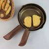 two gold skillets with leather handle heat protection