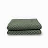 A folded green and white checkered fabric item, likely a blanket or towel, shown on a clean white background.