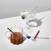 Colourful glass spoons styled with iced coffee and sparkling water in scalloped glassware – modern drinkware and accessories for everyday rituals.